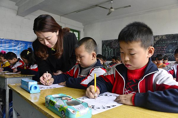 2014年3月25日，周楼小学小学生在吴海燕老师的指导下进行正确书写汉字。