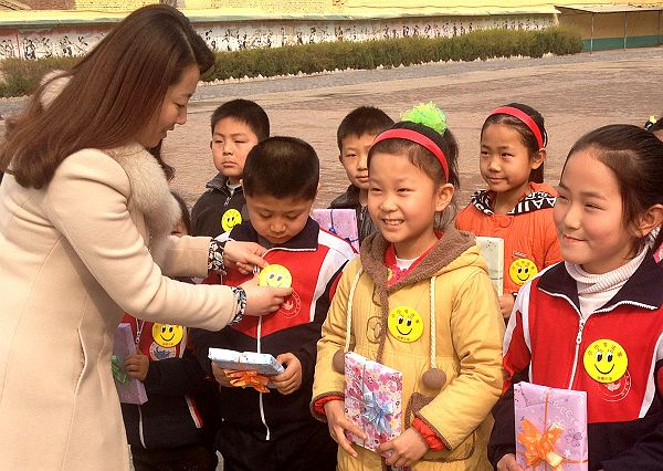 图为周楼小学校长吴海燕为评选出的“小小书法家”佩戴奖章。