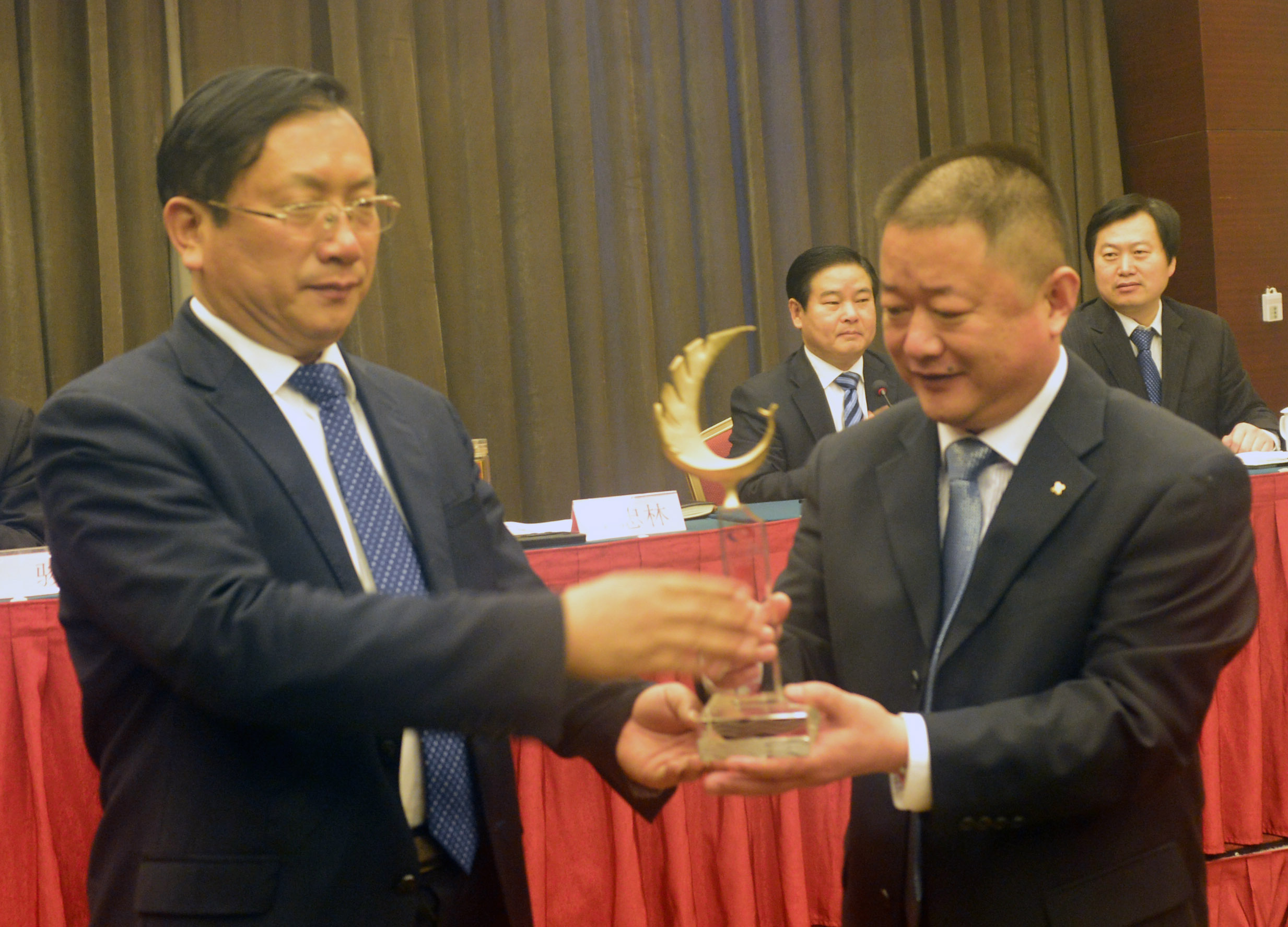 2014年3月28日，山东省聊城市市长王忠林（左） 在全市质量工作会议上为山东中通钢构建筑股份有限公司总经理 ...