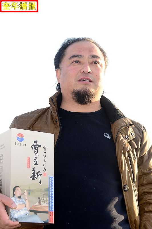 书法家贾立新与他定制的茅台镇出产的“贾立新酒”。