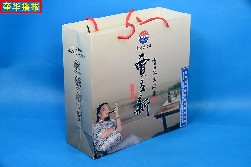 书法家贾立新与他定制的茅台镇出产的“贾立新酒”。